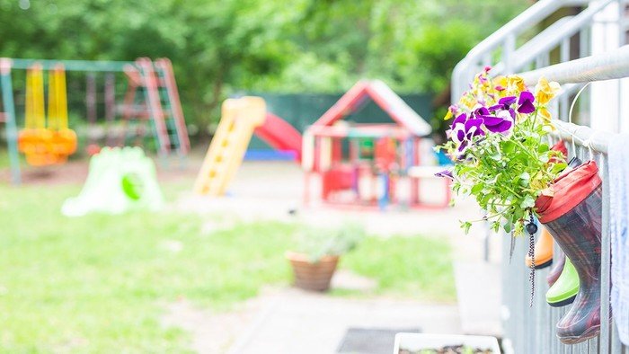 Außengelände der Kita Dreieinigkeit mit Blumen und Spielgeräten