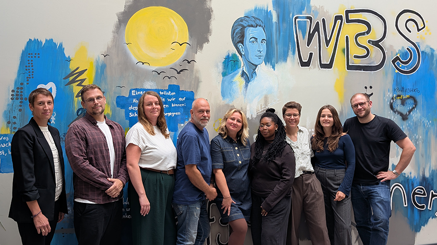 Mitarbeitende im Schulteam vor Graffitiwand
