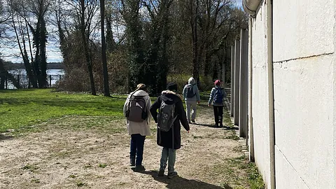 Gruppe läuft entlang alten Berliner Mauerresten