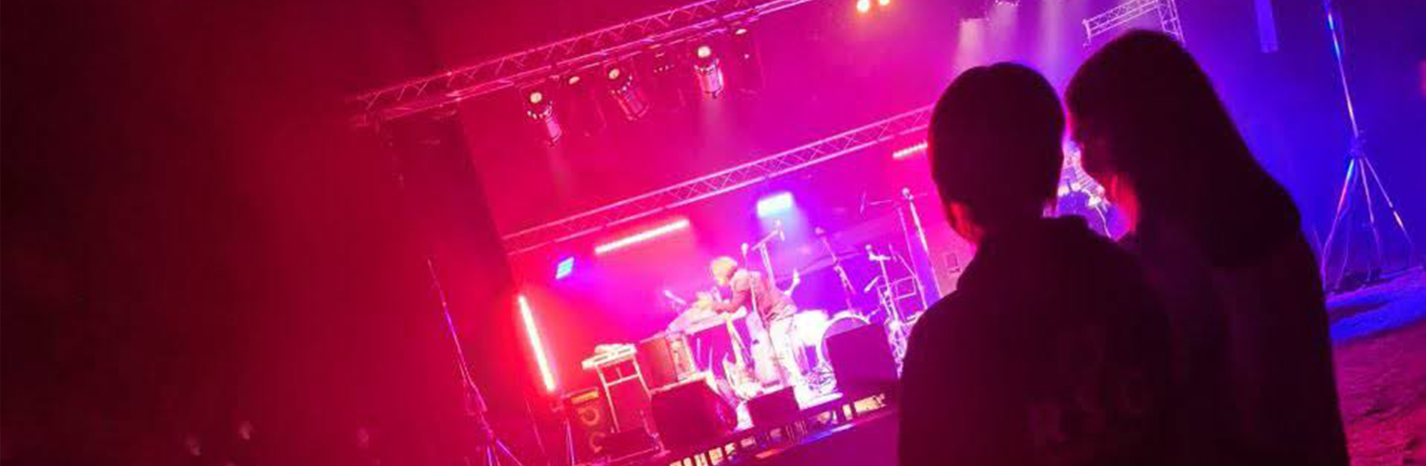 2 Jugendliche vor Bühne mit Lichtshow