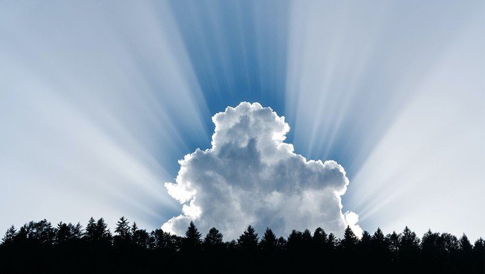 Lichtstrahlen dringen hinter einer Wolke hervor