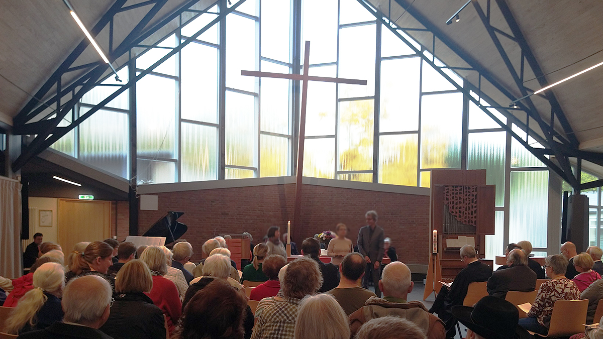 Gottesdienst in der neugeweihten Jeremia-Kirche, Blick auf den Altarraum mit Kreuz und Orgel