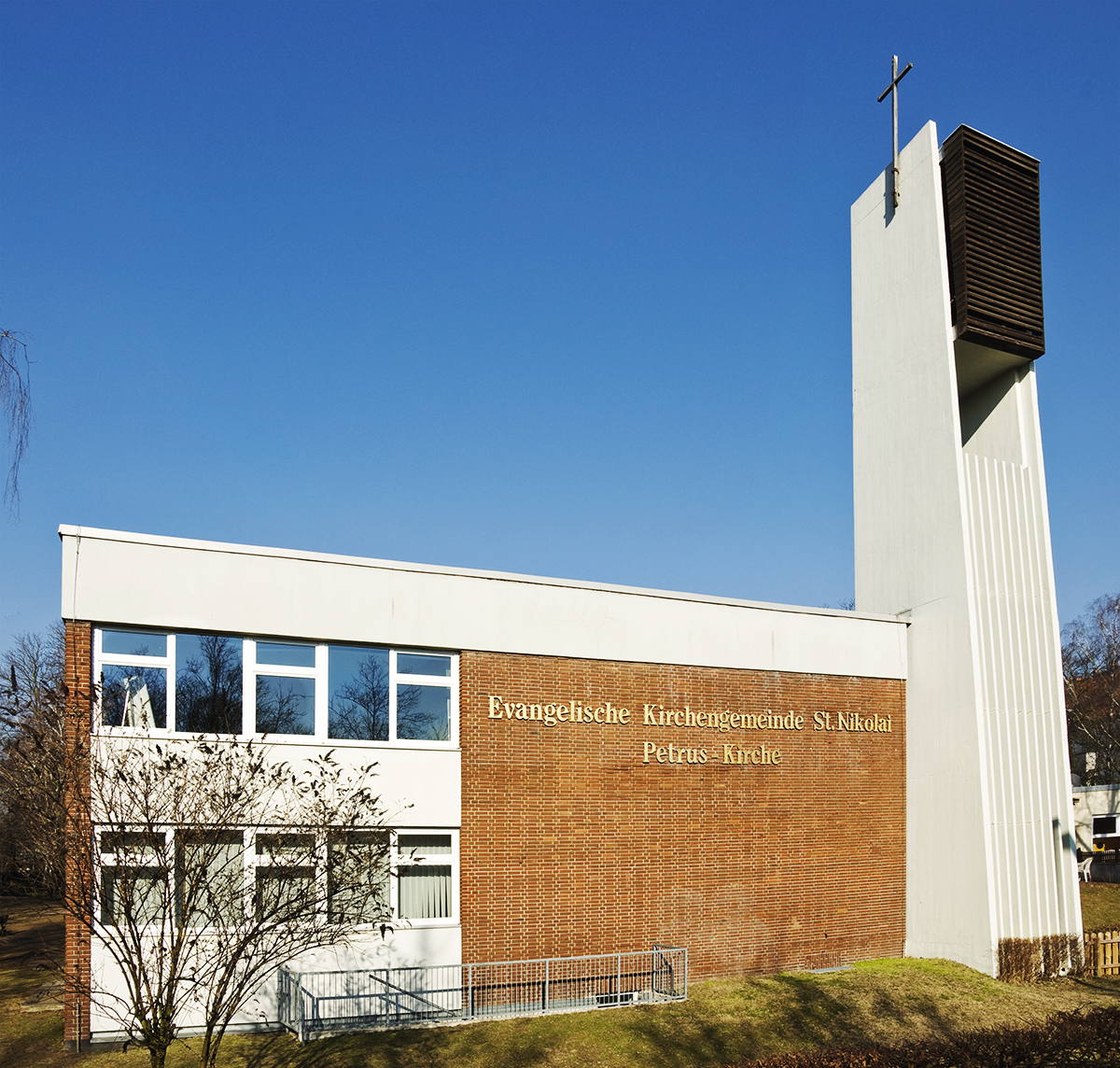 St. Petruskirche: ein moderner Kirchenbau, Front mit Klinker verkleidet, weißer Turm mit Kreuz