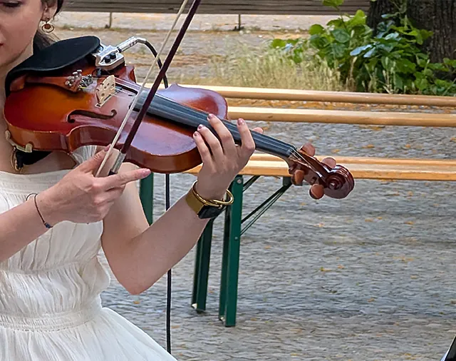 Frau im weißen Kleid spielt Geige