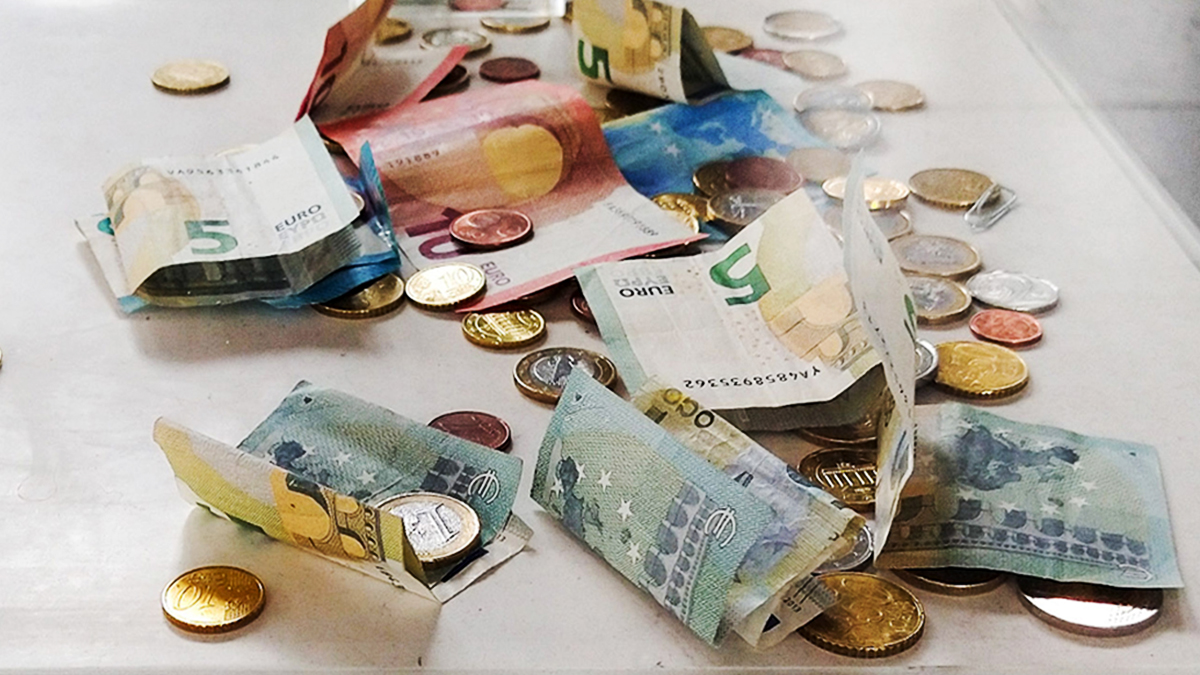 Symbolbild: Geldscheine und Münzen in einer Spendenbox