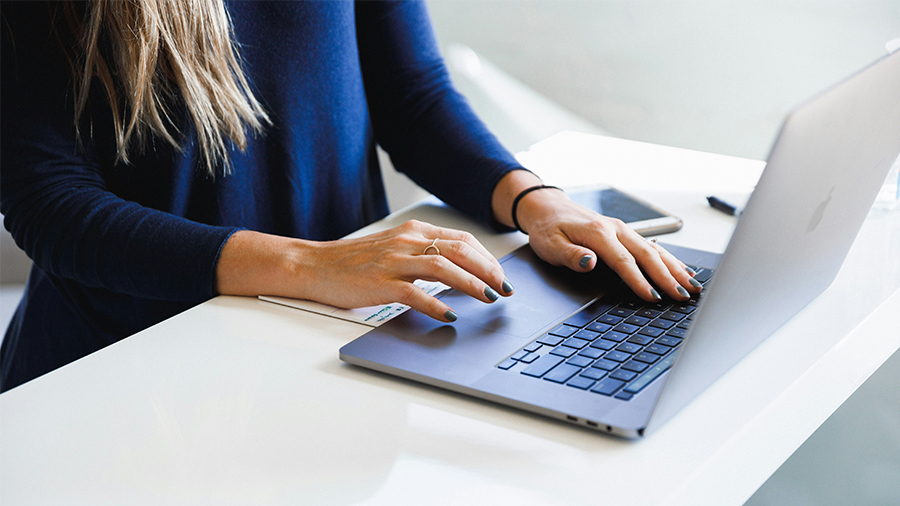 Eine Frau arbeitet an einem Laptop.
