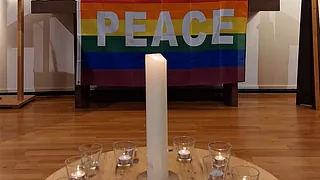 Kerzentisch und Altar mit Regenbogen-PEACE-Flagge