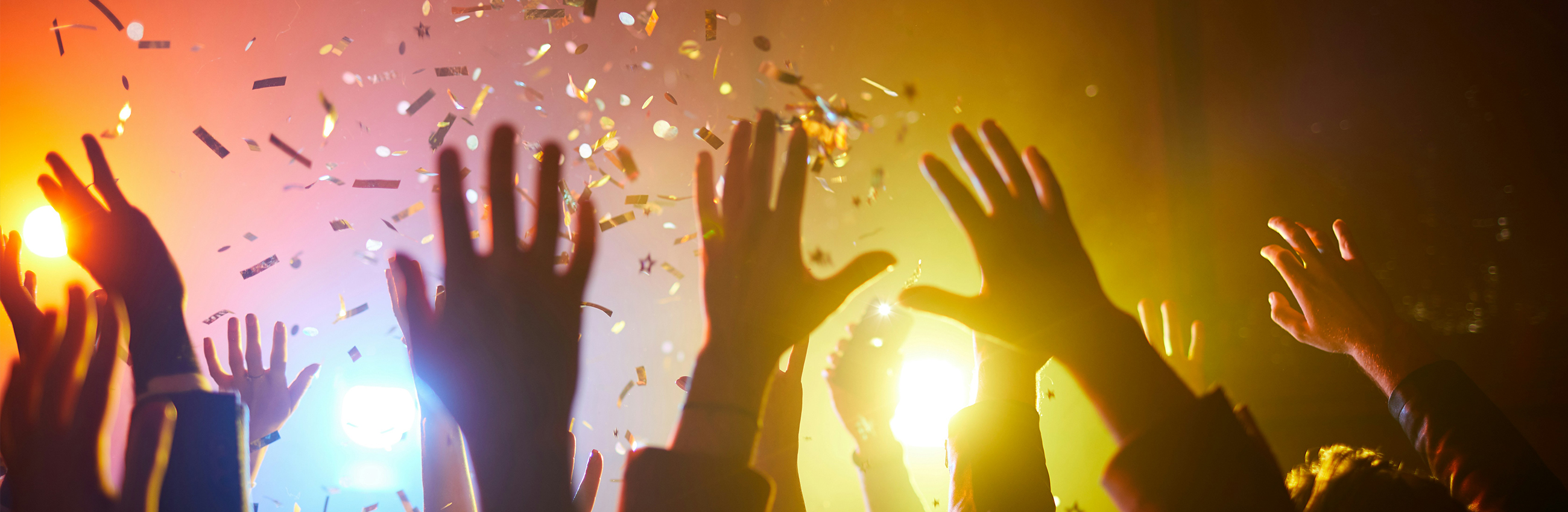 Partystimmung: Konfettiregen und erhobene Hände