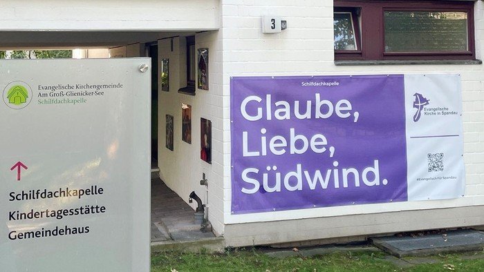 Lila Banner am Gebäude: Glaube, Liebe, Südwind.